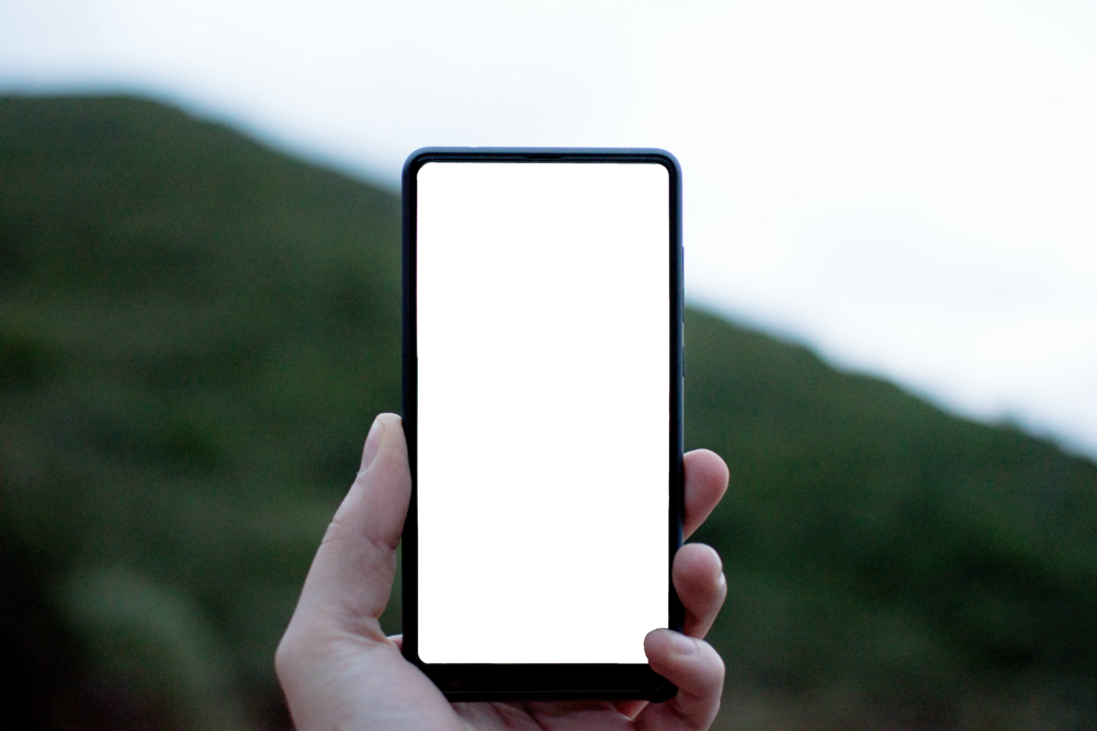 Mobile Mockup: hand holding phone in the hills